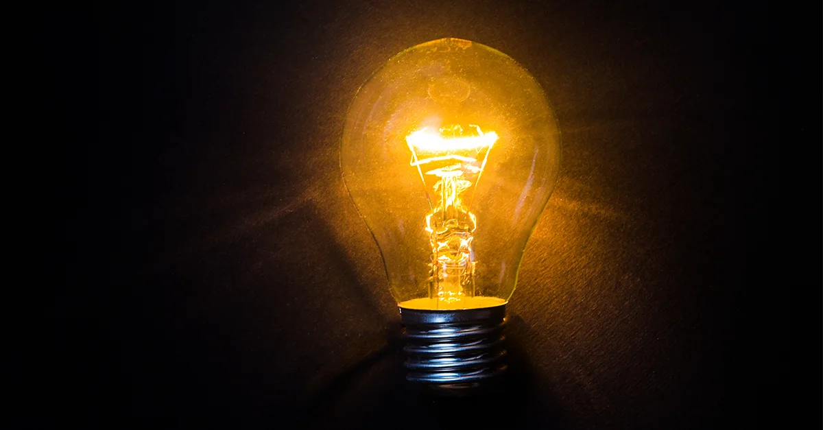 A glowing lightbulb illuminated against a dark background