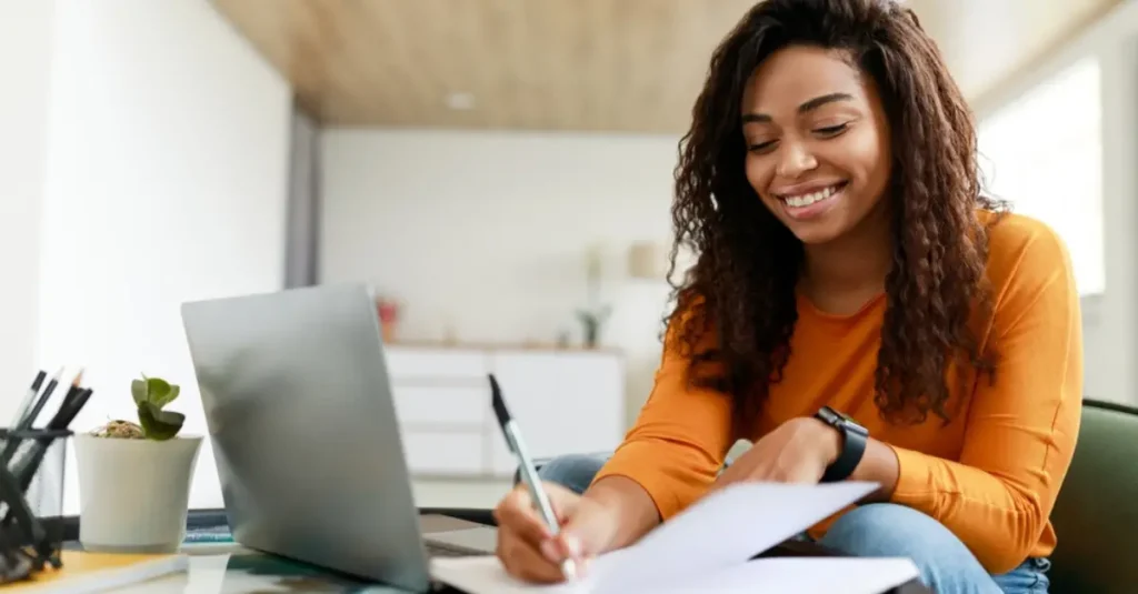 A woman enjoying working from home sitting at a low table on her laptop