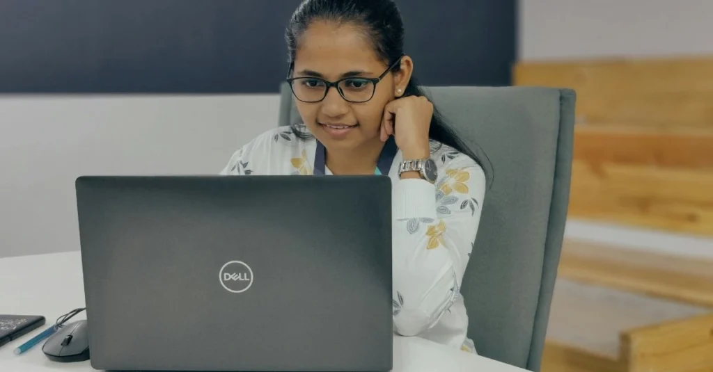 young female HR professional reviewing pay gap data on laptop