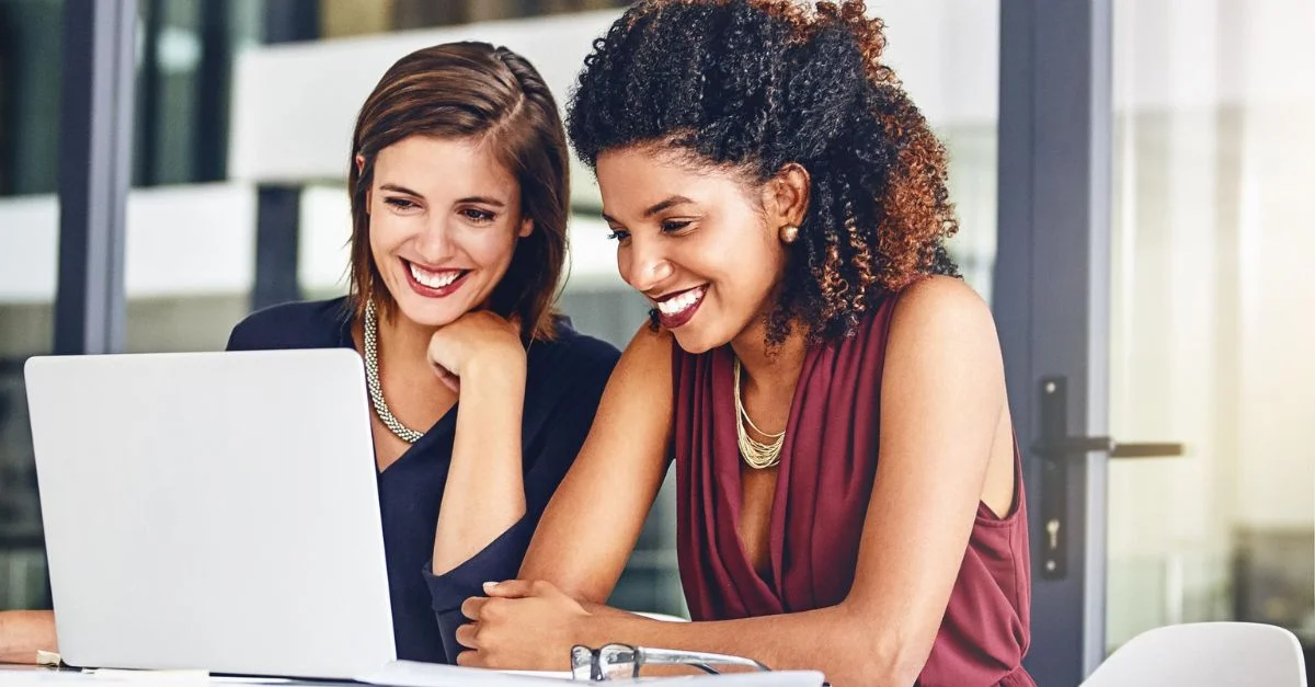 Smiling HR colleagues at laptop
