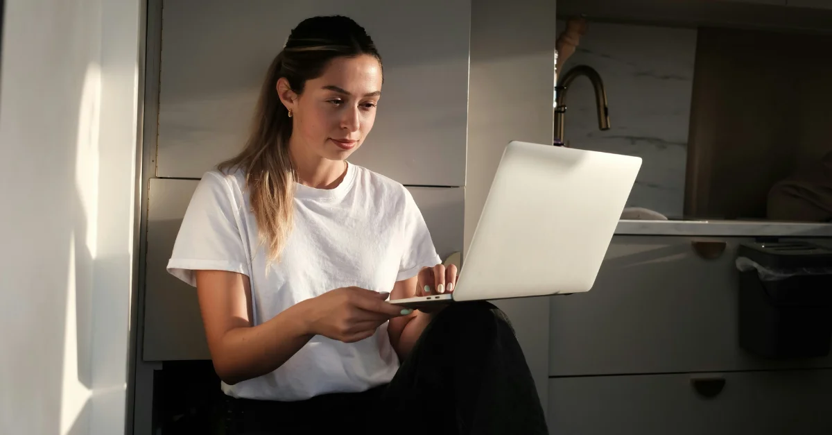 HR compensation manager reviewing the Brightmine Pay Trends 2025 report on her laptop.