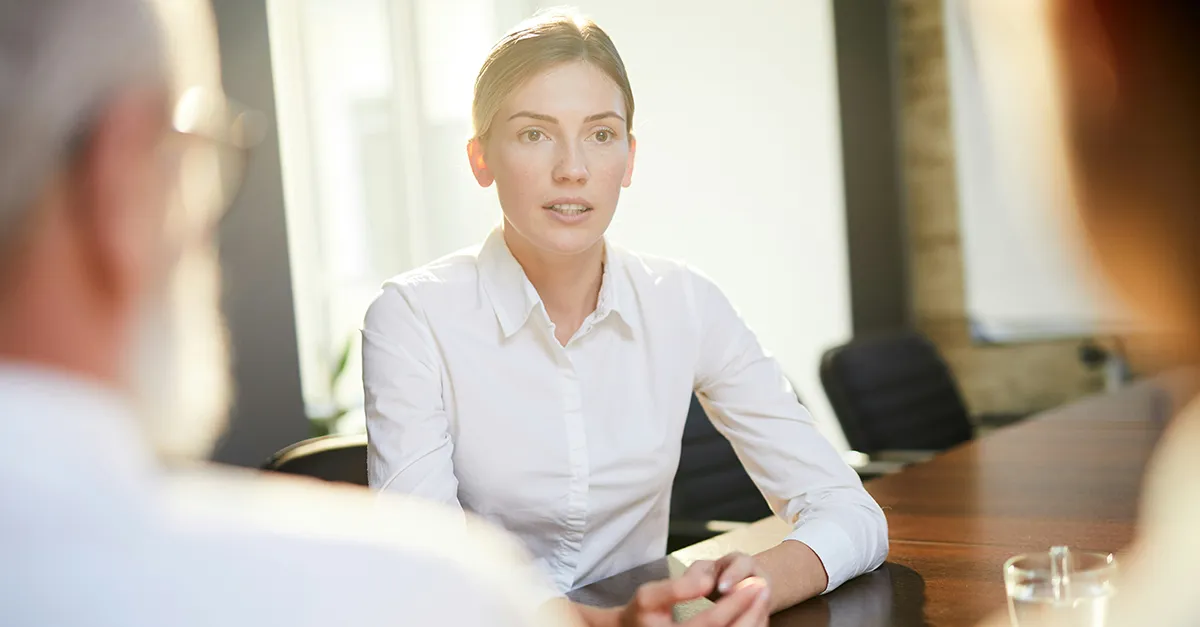 Two professionals interviewing a candidate during a business meeting at a conference table