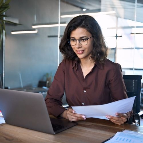 young female legal professional reviewing Brightmine HR law updates on a laptop