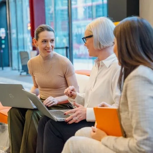 Three female colleagues on the legal team meeting to discuss upcoming compliance changes