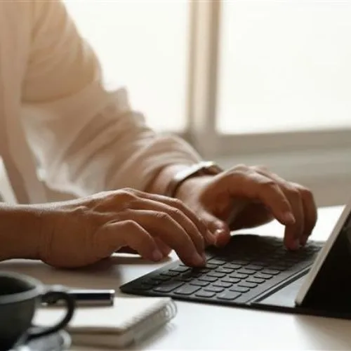 Head of HR for a university typing on a laptop