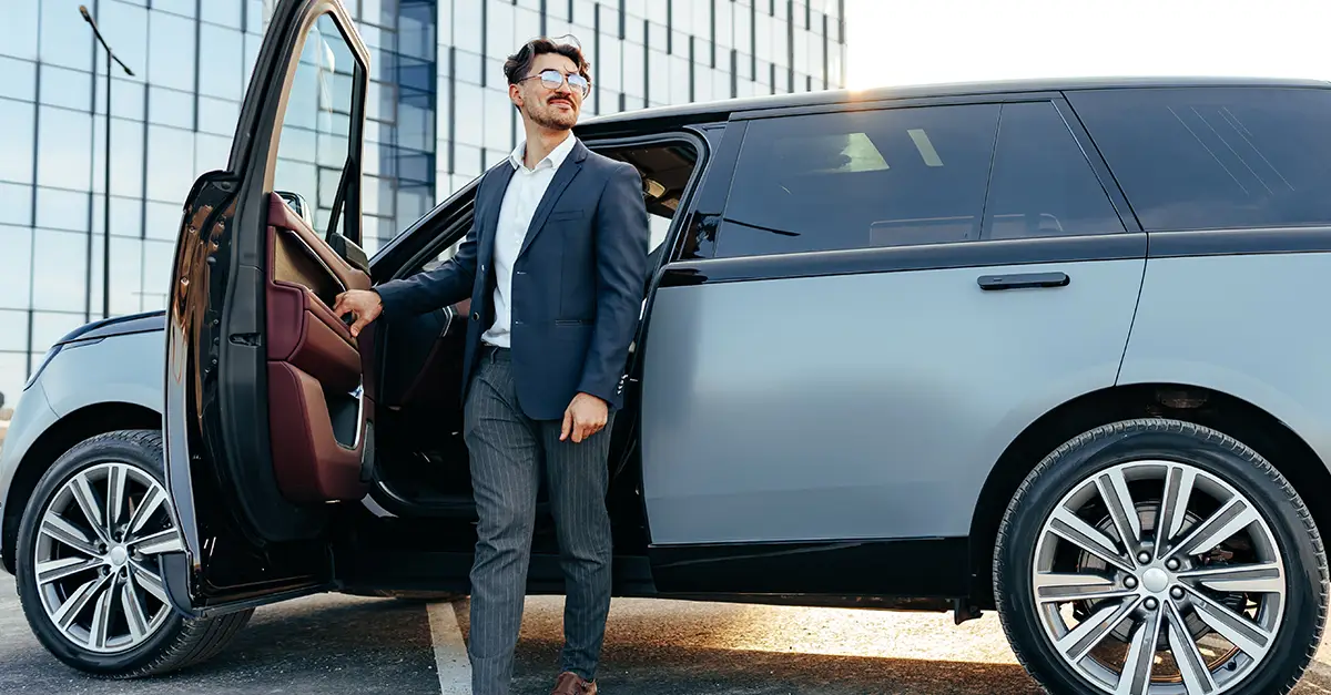 Individual stepping out of a sport utility vehicle parked in an urban environment.