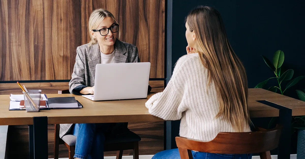 Two professionals talking during a meeting in an office