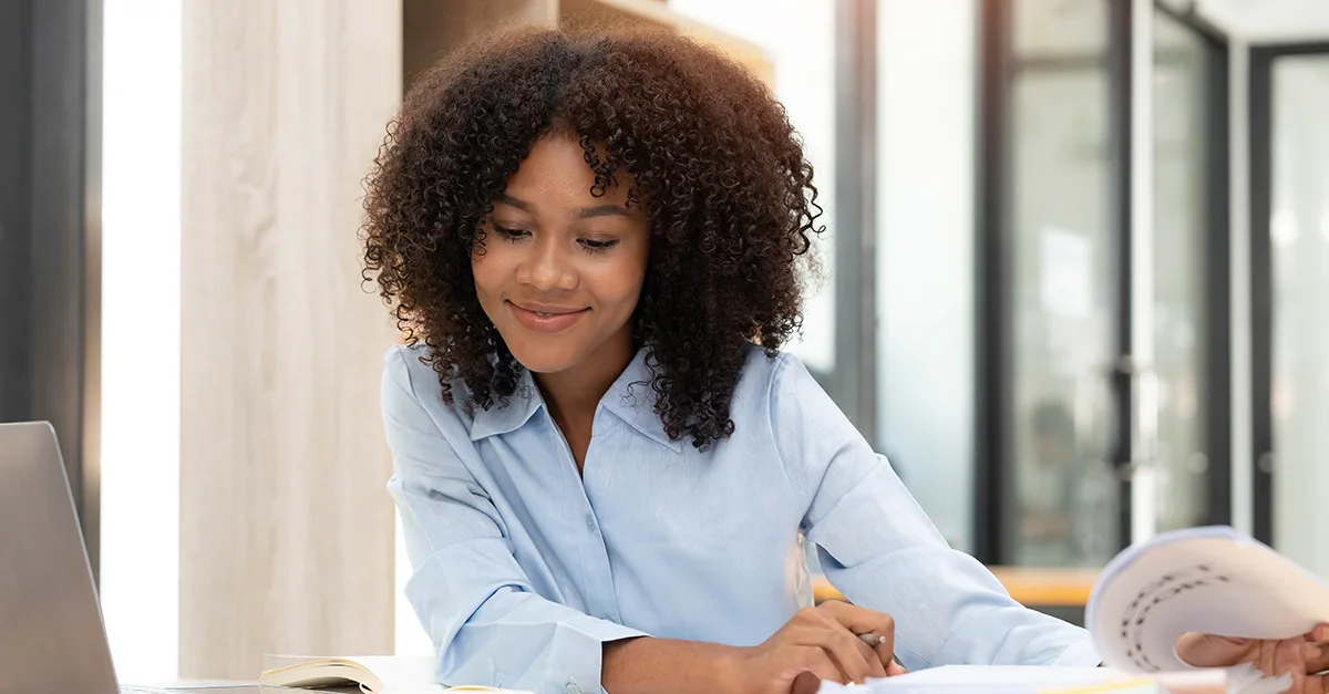 Woman writing notes while working at a desk