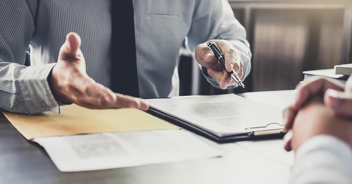 Business professionals discussing and signing documents