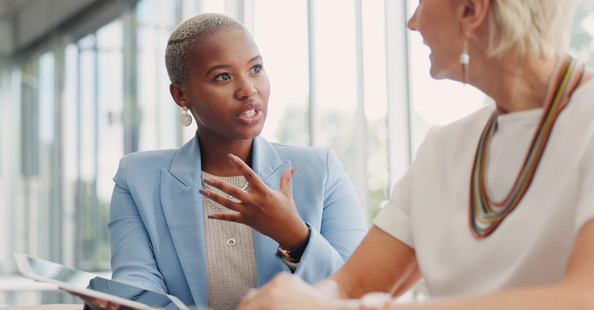 Two business professionals engaged in a workplace discussion during an office meeting