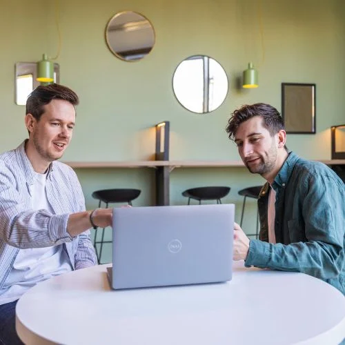 Manager walking an employee through their performance review on a laptop.