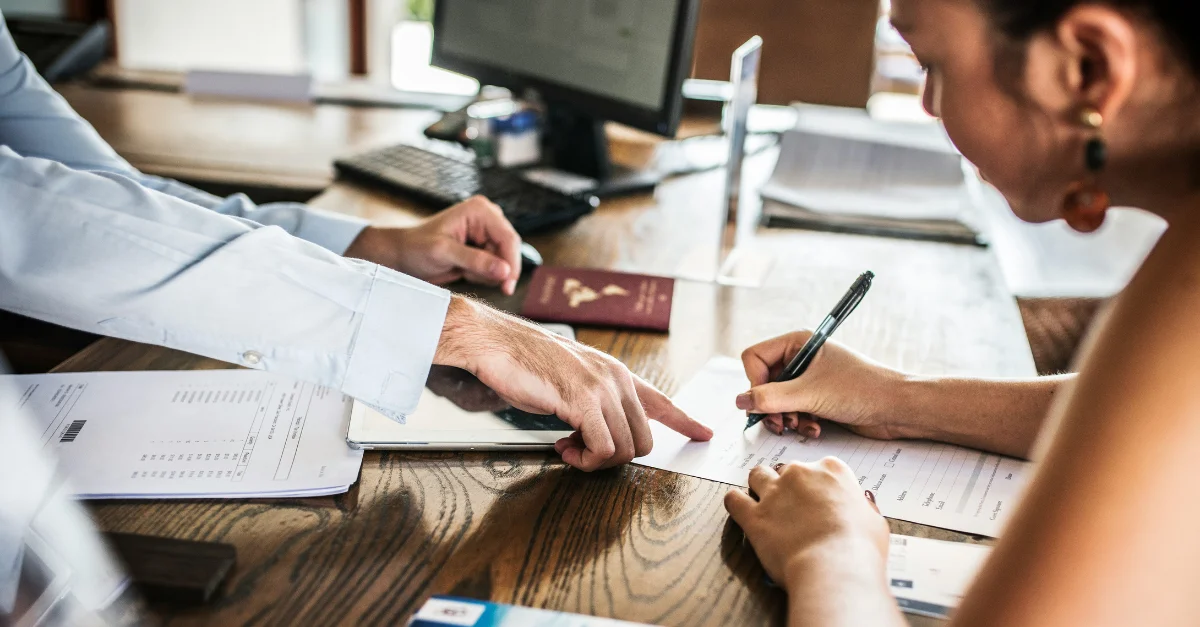 Employee signing documents to receive their H-1b visa after program changes.