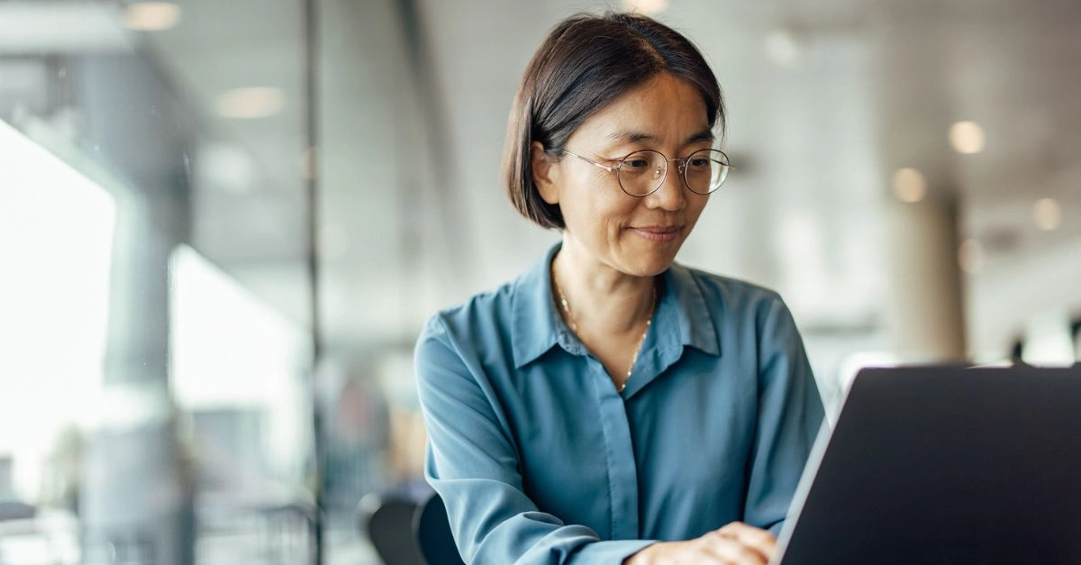 Older female employee working on a laptop in an office