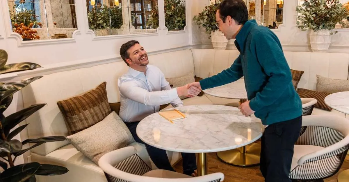 two businessmen shaking hands at the start of a meeting