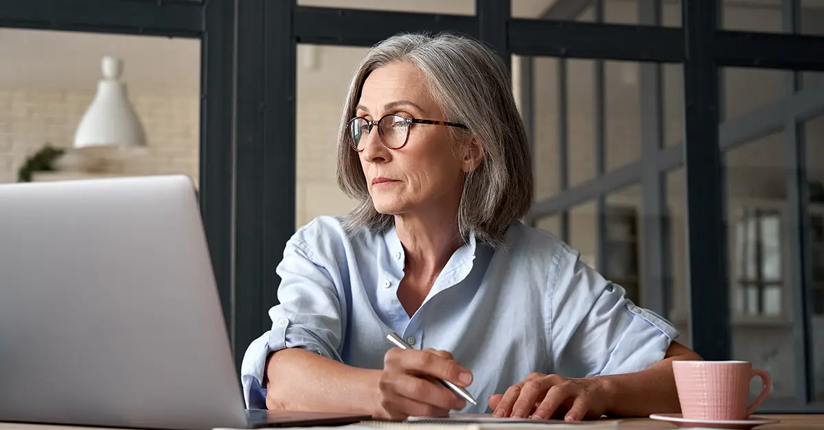 Brightmine office worker taking notes from laptop