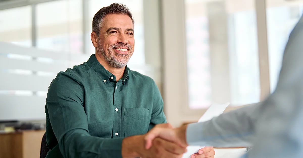 Smiling business professional shaking hands during a successful office meeting or interview