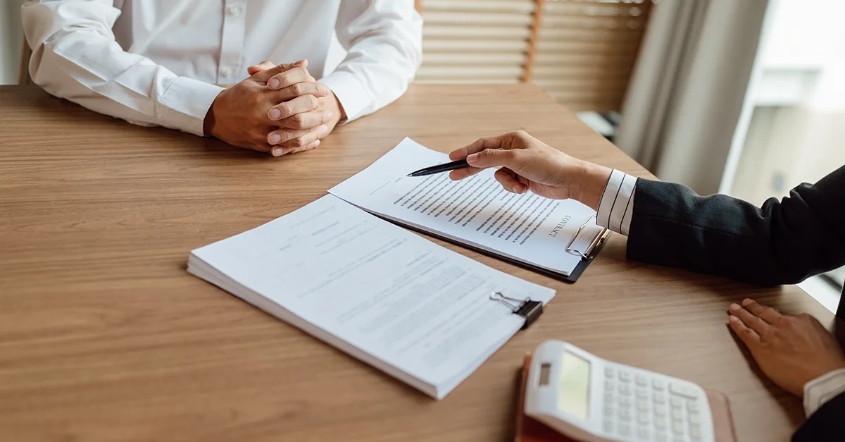Hiring manager reviewing documents with a job candidate during an office interview meeting