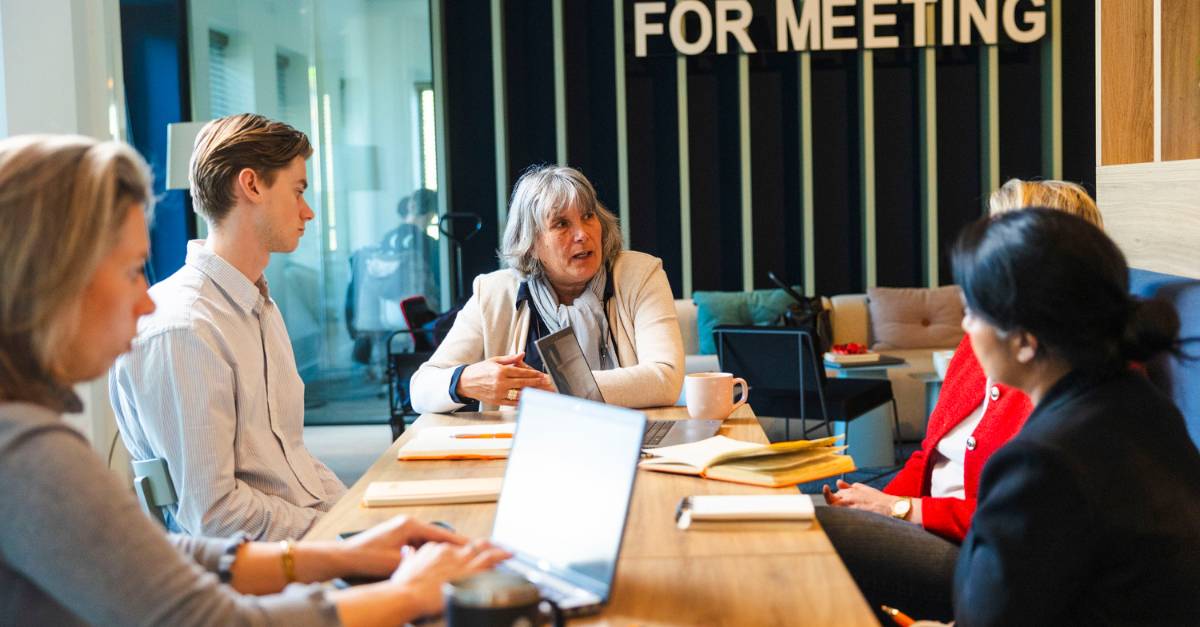 groep werknemers aan tafel overleggen brightmine